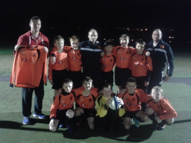 Chris Bull Owner/director of First Aid North East presenting the U12s with their new strip