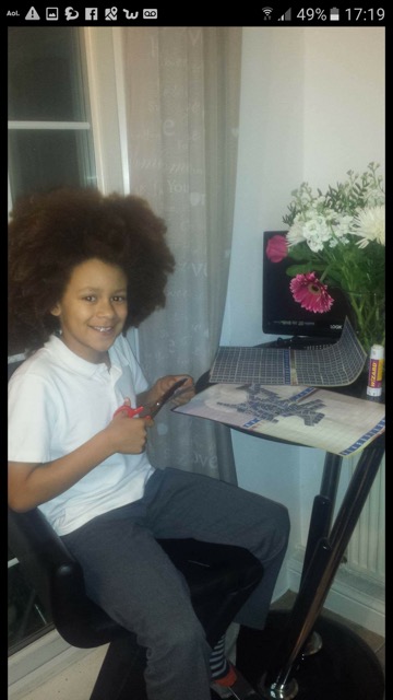 Leo from the u10s Jets cutting and sticking for our wish tokens campaign