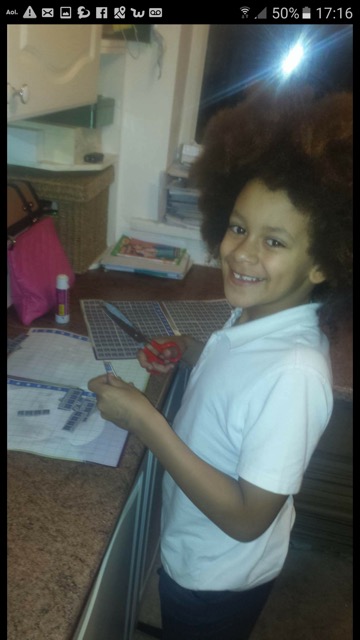 Leo from the u10s Jets cutting and sticking for our wish tokens campaign